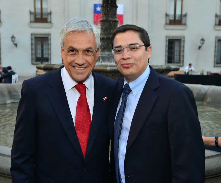 two businessmen in suits pose for the camera