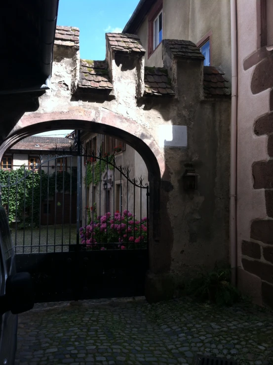 a gate leading to a courtyard on the side of a house