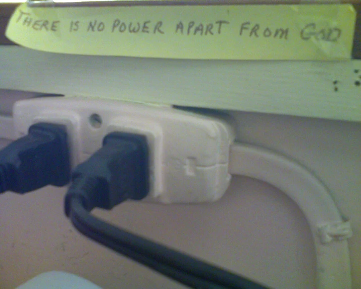 the power cord for a computer that is plugged in and has been placed between two wires