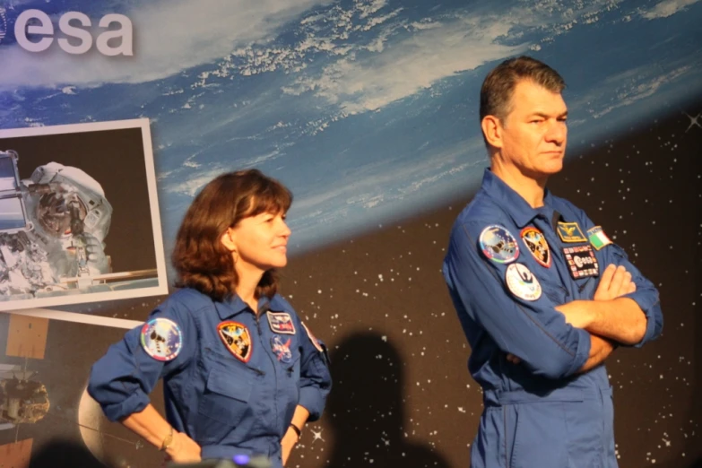 a man and woman in space suits standing next to each other