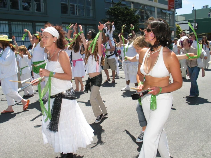 some people are marching in a parade with green ribbons