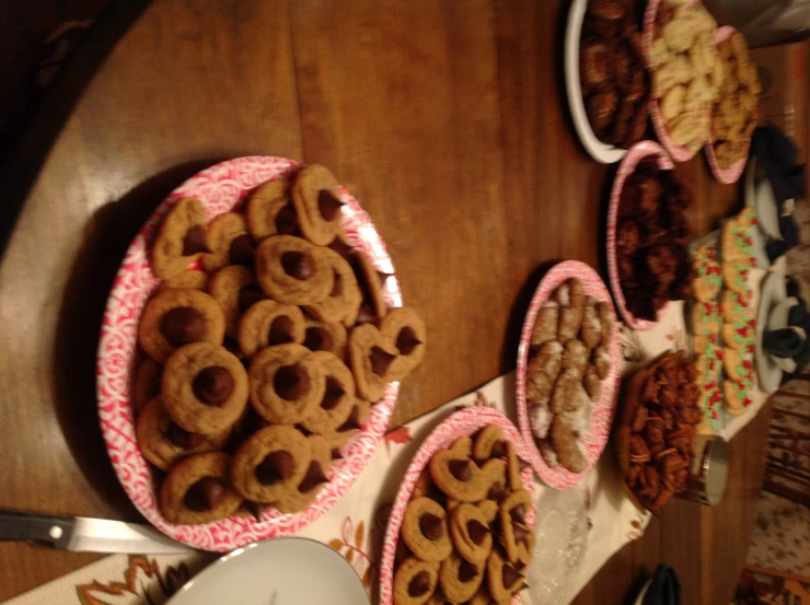 lots of cookies that are on plates next to a table