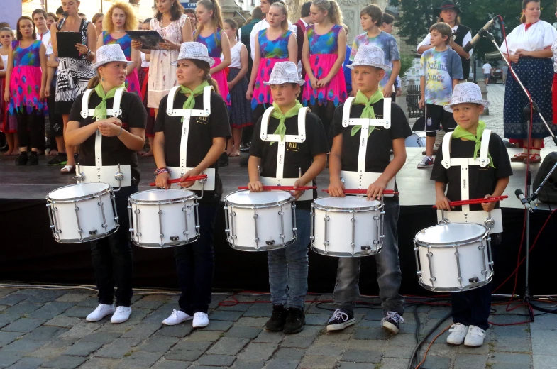 several young men are wearing costumes and holding drums