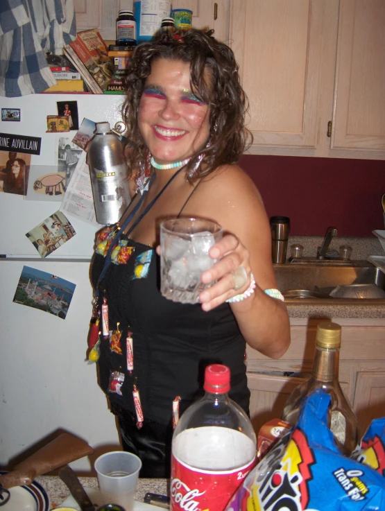 woman with glasses and holding up a drink in the kitchen