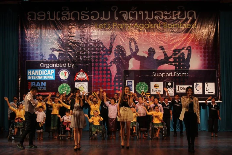 a crowd of children standing on stage at an event
