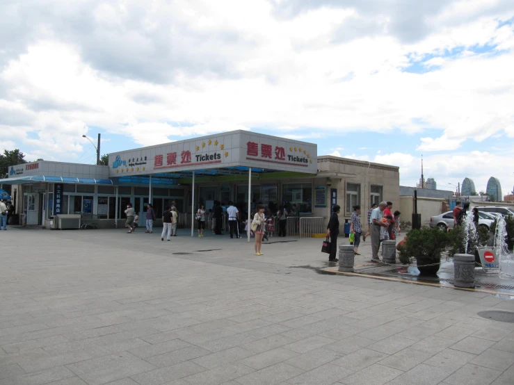 several people gather in front of a shopping center