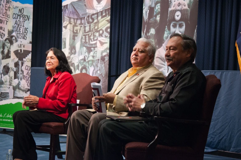 three people sit on chairs during a panel discussion