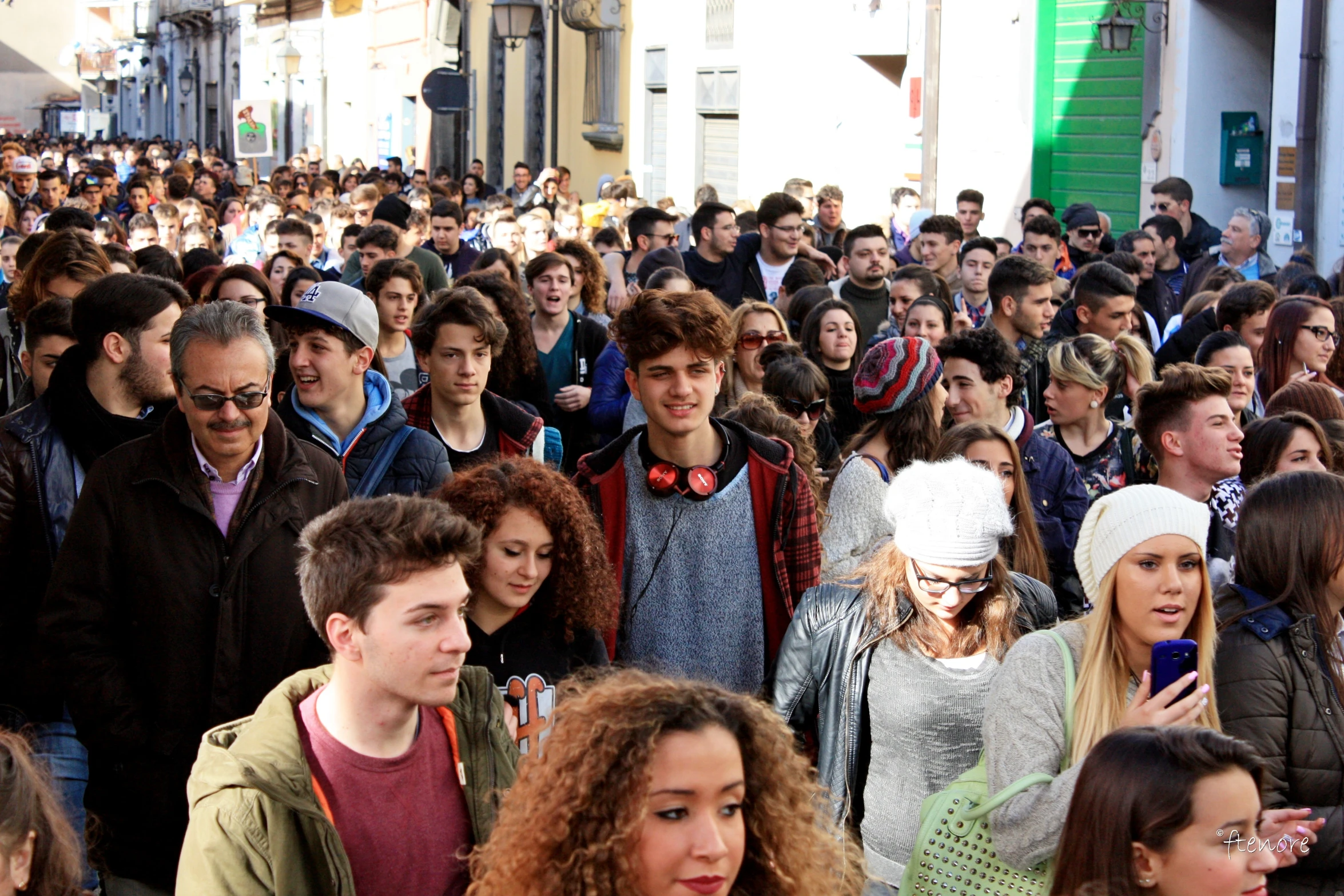 a large crowd of people walking down the street