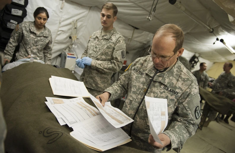 an army man with paperwork at the military camp
