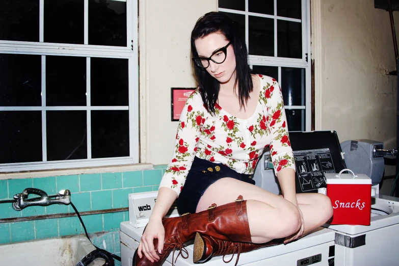 a woman with glasses posing in a kitchen