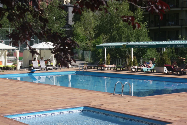 a large swimming pool is situated in the middle of a city park