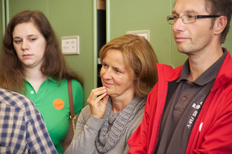 a group of three people standing around each other