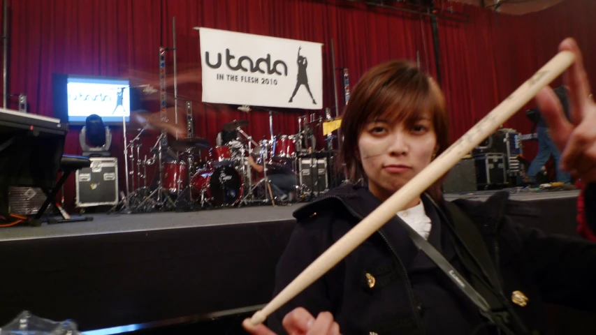 a person in a music studio holding a wooden stick
