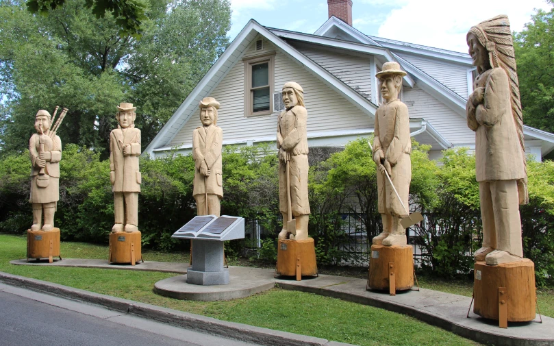 some sculptures are sitting on the sidewalk outside of a house