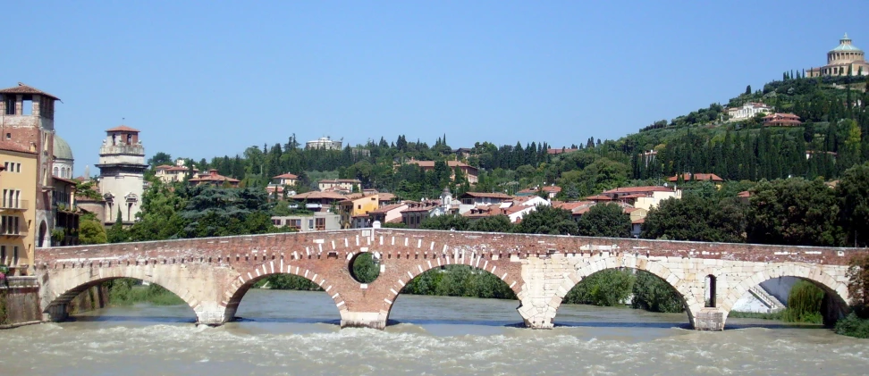 an old, brick bridge crossing over a small river