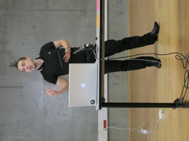 a person standing on a table using a lap top