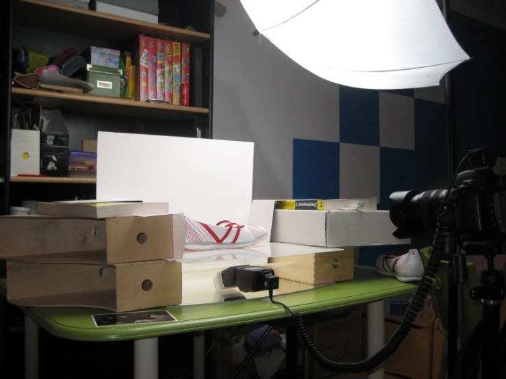 an electric lamp, camera, box, and boxes on a table