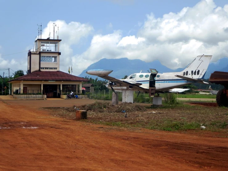 a airplane and building in the background under a cloudy sky