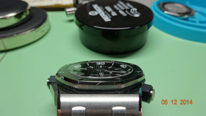 a watch sitting on top of a table with different tools
