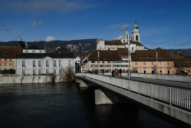 a river in front of a bridge with several buildings