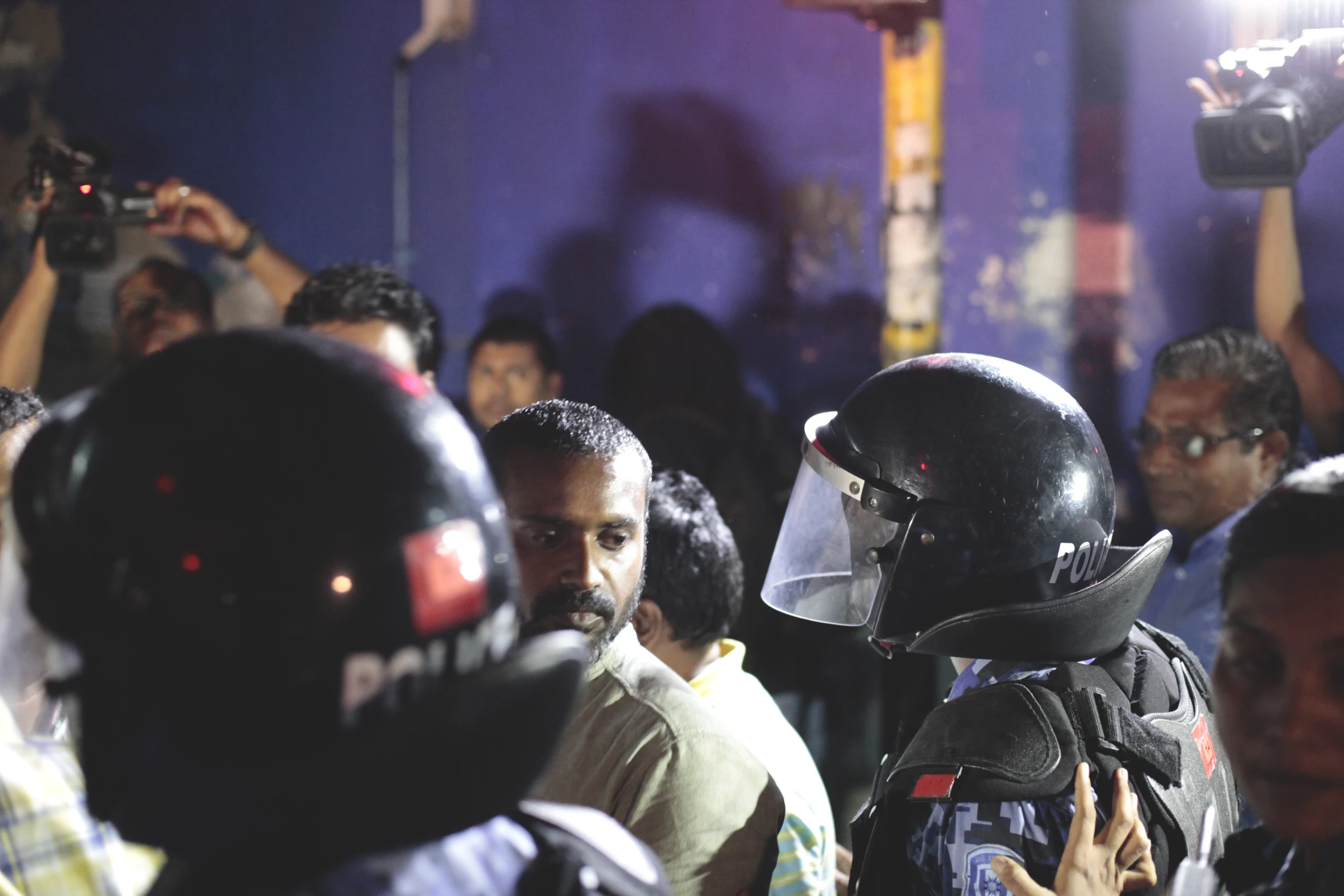 a man in a mask, talking to the media