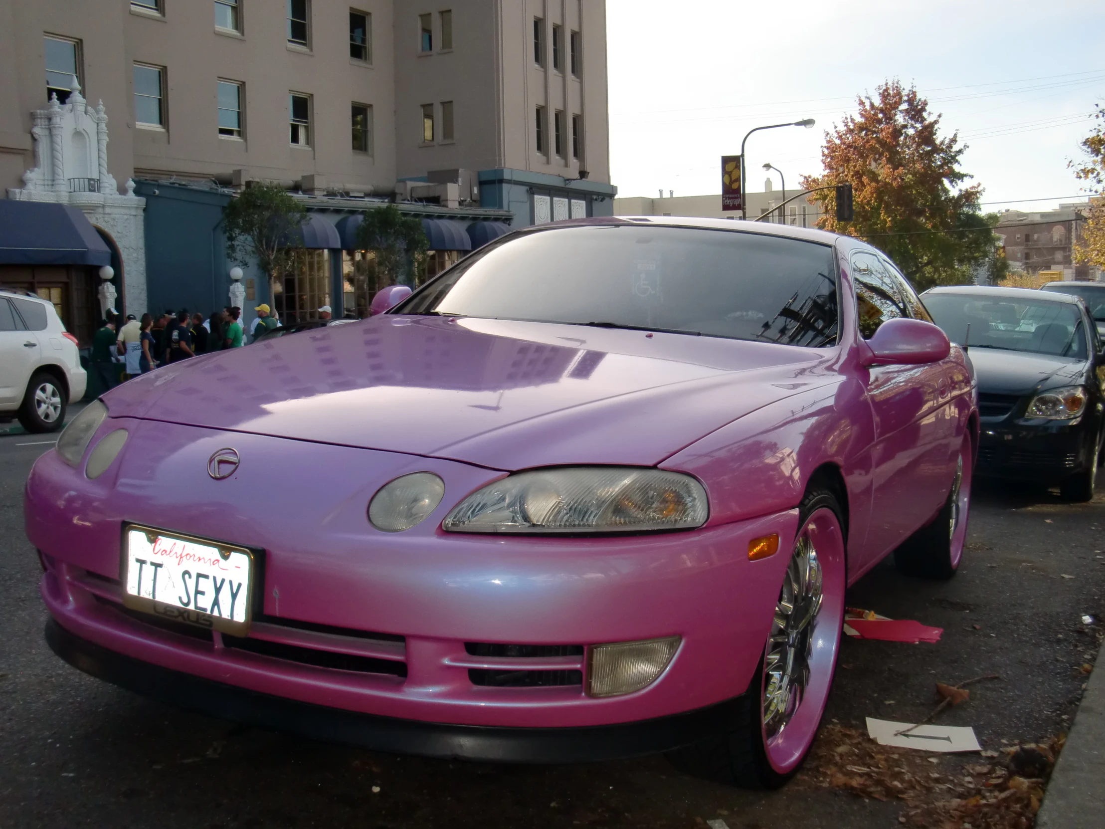 a pink car is parked by itself on the street