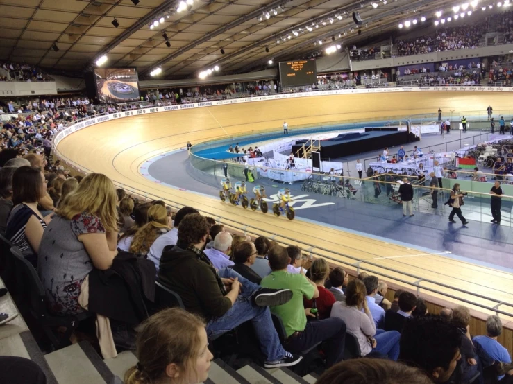 a large crowd watches an outdoor ring at night