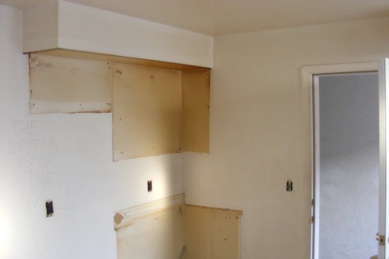 an empty room with unfinished cupboards that are being painted