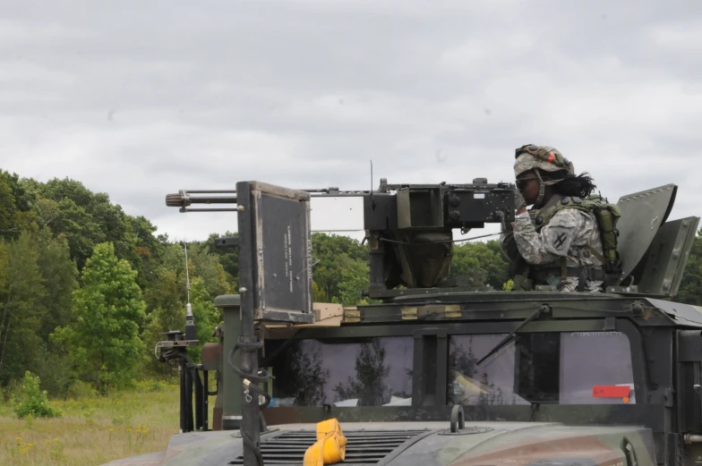 a soldier sitting in the back of a military vehicle