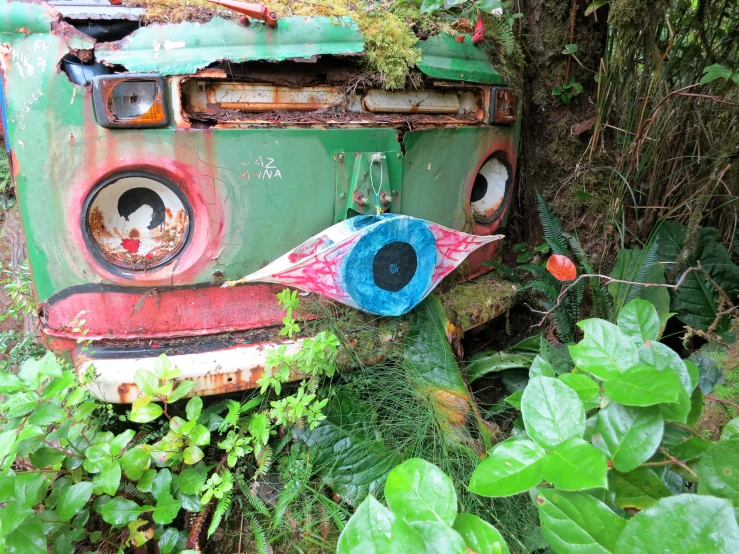 an old bus parked in a lush green area next to trees