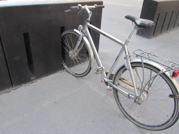 the bicycle is locked to the wall with no people around it