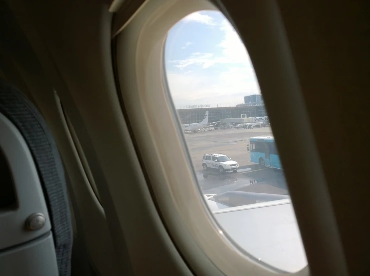 the view outside of an airplane window shows trucks parked