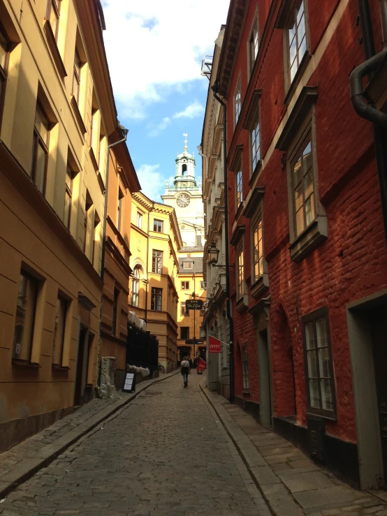 a narrow city street next to large brown buildings