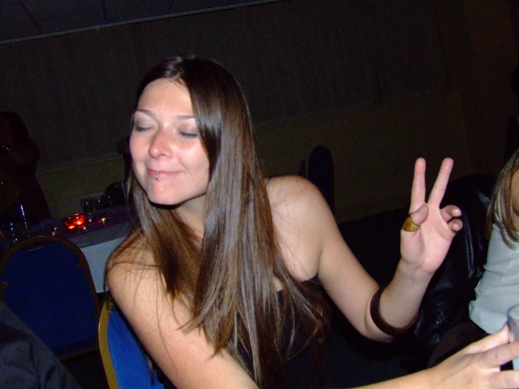 a girl is posing for a picture and making two fingers up