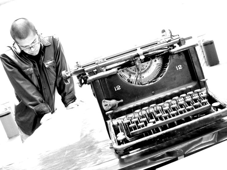 a man looking at an old fashioned typewriter