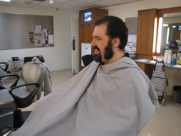 a man in a chair is getting his hair cut
