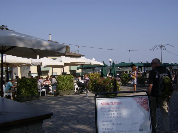 a patio that has people sitting down and standing