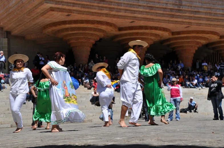 a group of people in white and green dresses