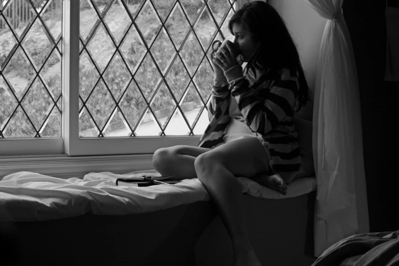 a woman talking on her cellphone while sitting in bed