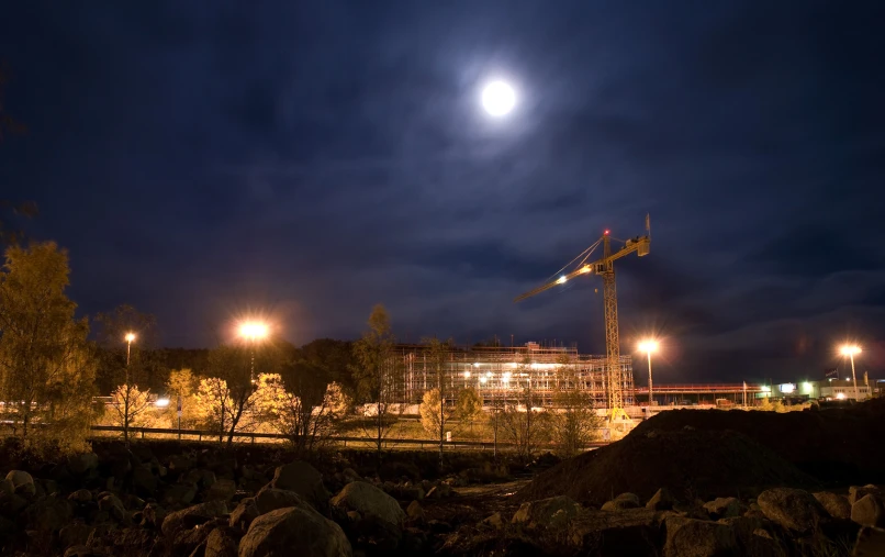 a view of construction site at night with moon and full moon in the distance