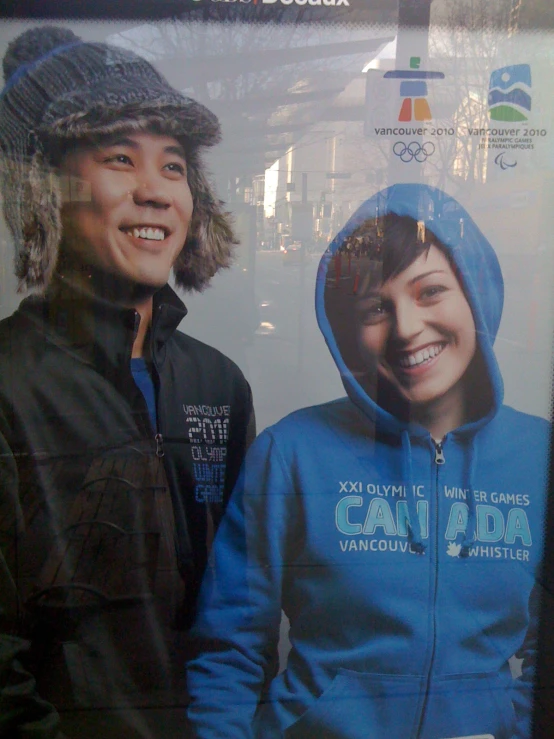 two people posing for a picture next to a poster