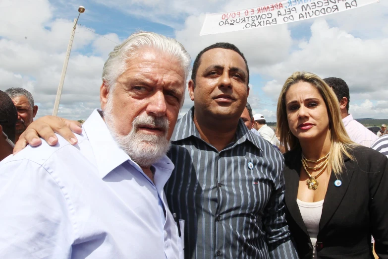 two men and a woman standing next to each other in front of a crowd