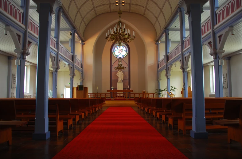 inside a church that has pews and a red carpet