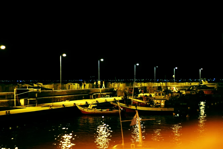 lights shine on boats docked in a marina