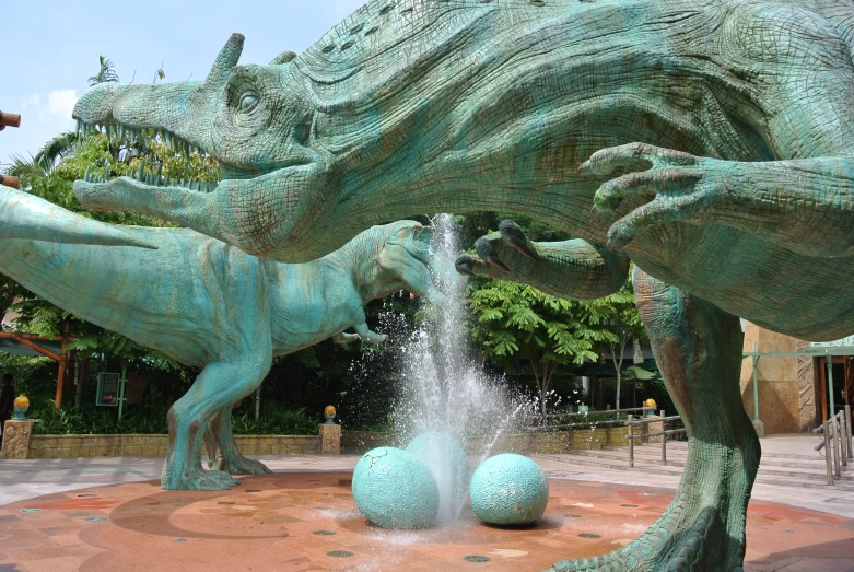 two green sculptures near each other with water coming out