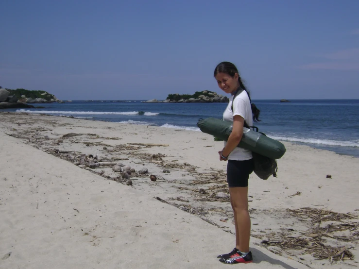 a girl on the beach carrying an object