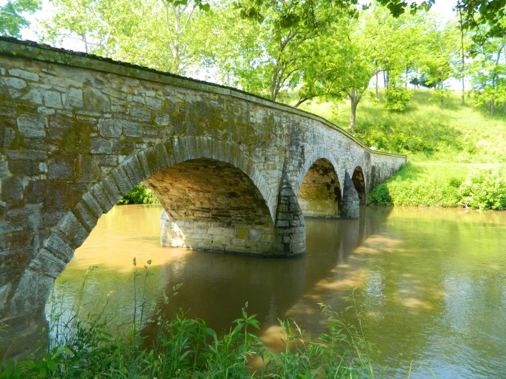 an old stone bridge crossing over a river