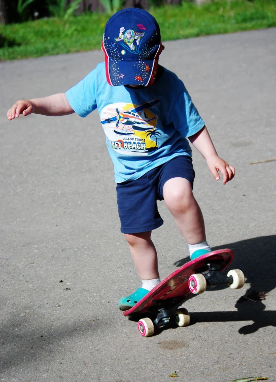 young child learning how to skate on asphalt