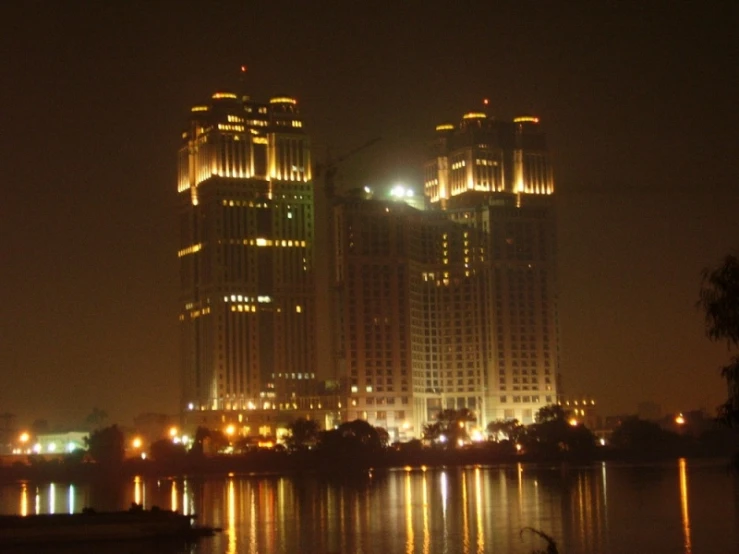 large buildings lit up in the night on the water