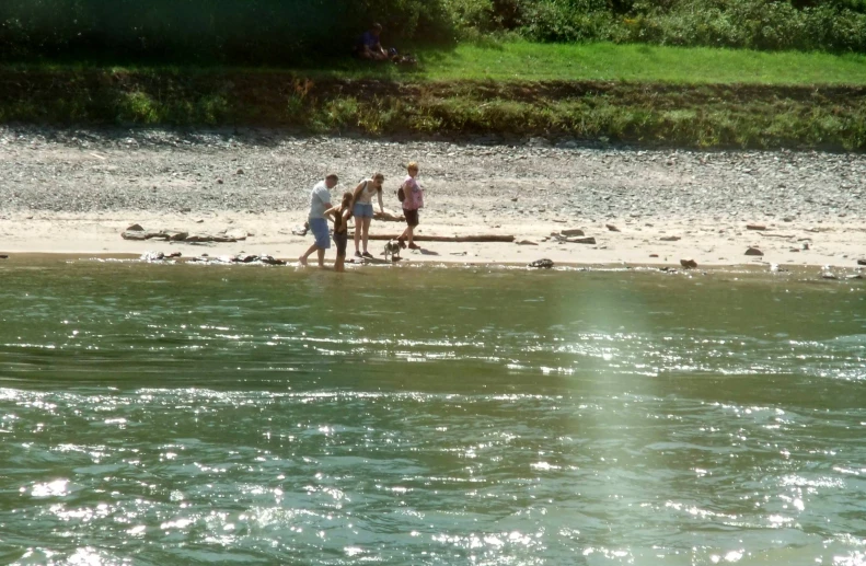 a group of people walking along the side of a river